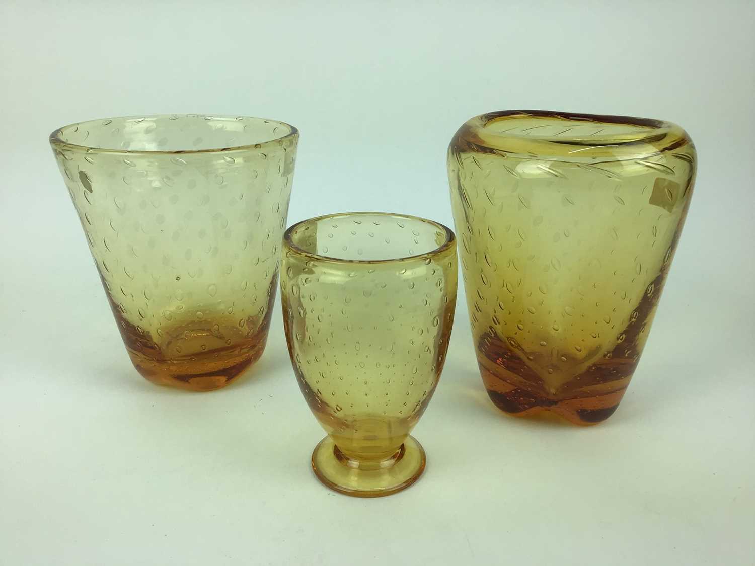 Lot 91 - Three Whitefriars Amber controlled bubble vases including one with original Whitefriars label, 18cm, 19cm and 14.5cm