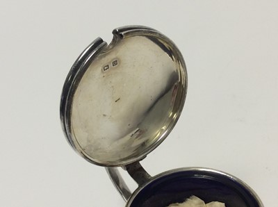 Lot 153 - George V silver three piece cruet set of drum form with engine with removable blue glass liners and matching spoons, (Birmingham 1928), maker Docker & Burn Ltd, pepperette 5.2cm in height, all at a...