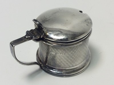Lot 153 - George V silver three piece cruet set of drum form with engine with removable blue glass liners and matching spoons, (Birmingham 1928), maker Docker & Burn Ltd, pepperette 5.2cm in height, all at a...