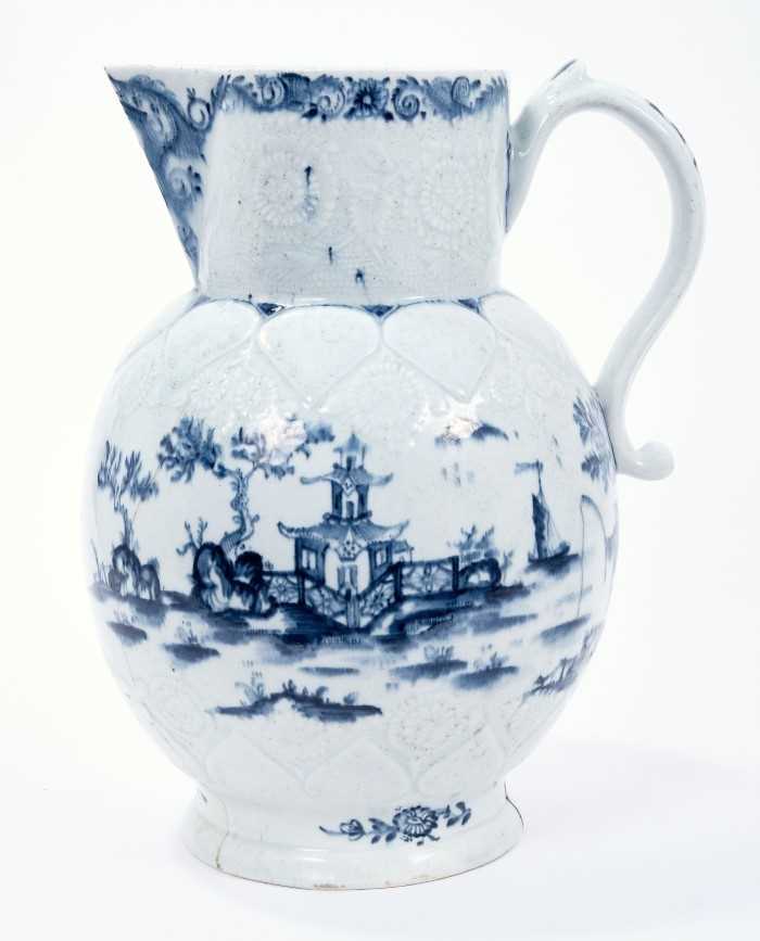 Lot 15 - Lowestoft jug, of large size, the neck moulded with flowers and leaves, the shoulder with lappets and flowers, painted in blue with a fisherman within an elaborate Chinese river scene, painter's nu...