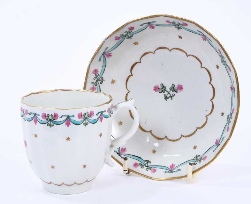Lot 60 - Lowestoft coffee cup and saucer, of faceted form with a scrolled handle, the centre in pink and green with with a flower sprig within a gilded band, a 'Bungay' border enclosing a band of gilt stars...