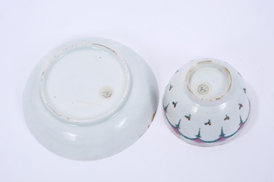 Lot 65 - Lowestoft tea bowl and saucer, enamelled with a wheel-like design in green and pink, within a red and black ermine border, 11.9cm diameter