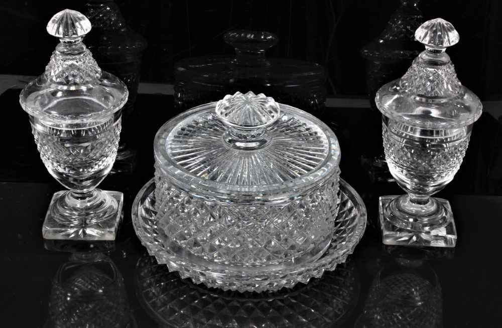 Lot 44 - Georgian cut glass butter tub and lid on stand, together with a pair of cut glass urns and covers