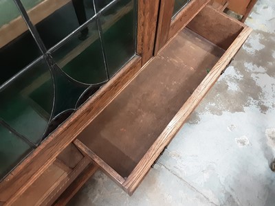 Lot 1025 - Early 20th century oak bookcase/display cabinet with shelved interior enclosed by two tinted and leaded glazed doors, single drawer below on spiral twist supports, 125cm wide, 41cm deep, 181.5cm hi...